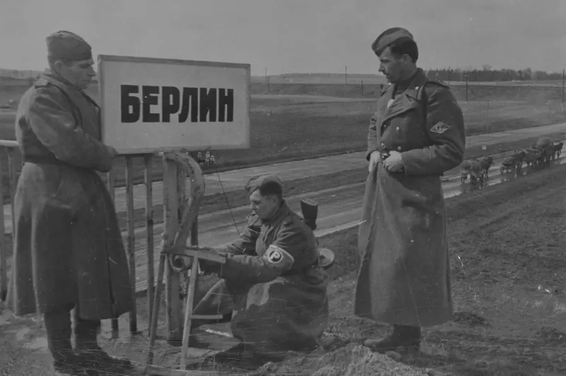 Soviet traffic controllers set a sign in front of a bridge at the entrance to Berlin