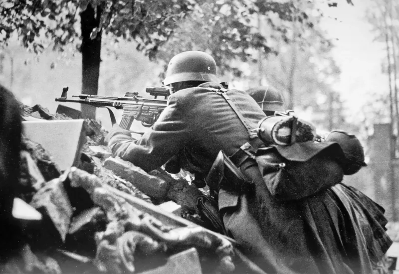 German soldiers in a defensive position on Kolonnenstrasse in Berlin. The man in the foreground is armed with an StG 44 assault rifle with a ZF-4 scope.