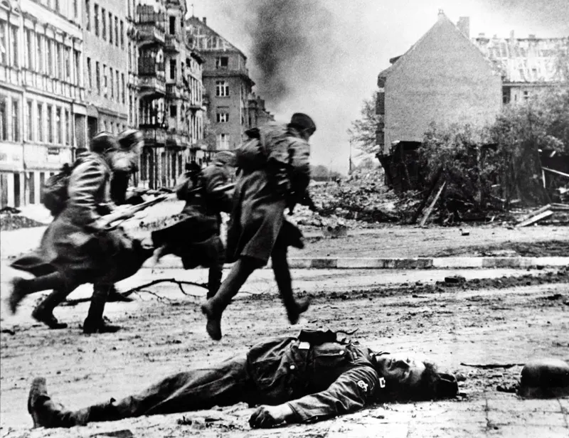 Soviet Red Army troops advance in Berlin to take up new positions (with a photomontage addition of a dead German soldier)