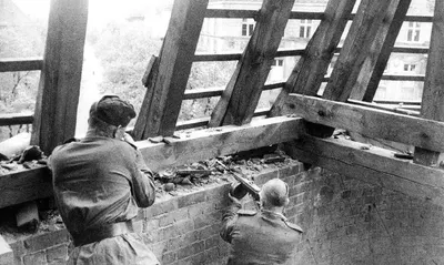 Soviet troops take up position in the roof of a building to advance through the city streets