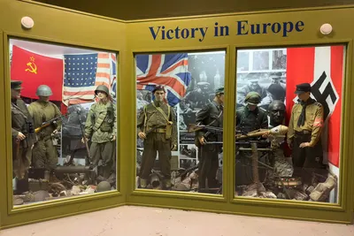 Arquebus Krigshistorisk Museum Norway. WW2 Allied Victory in Europe display. Uniforms weapons equipment USSR Red Army officer private US private British paratrooper battle dress German Waffen-SS Volkssturm Hitlerjugend flags photos B